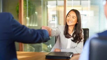 Asian female professional shaking hands with interviewer