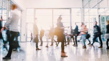 People walking through a busy building entrance, blurred motion.